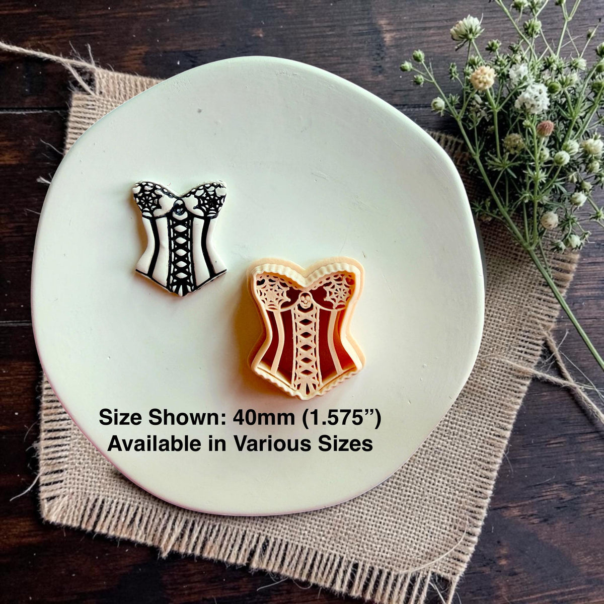 Finished corset earring displayed next to the 40mm spooky corset polymer clay cutter with size reference and multiple size availability.