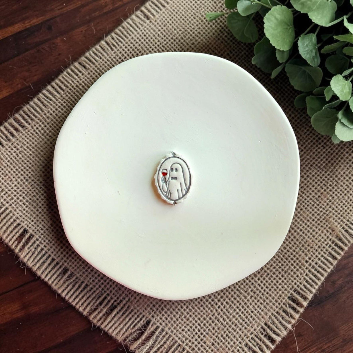 Boozy ghost polymer clay cutter displayed on a white ceramic dish.