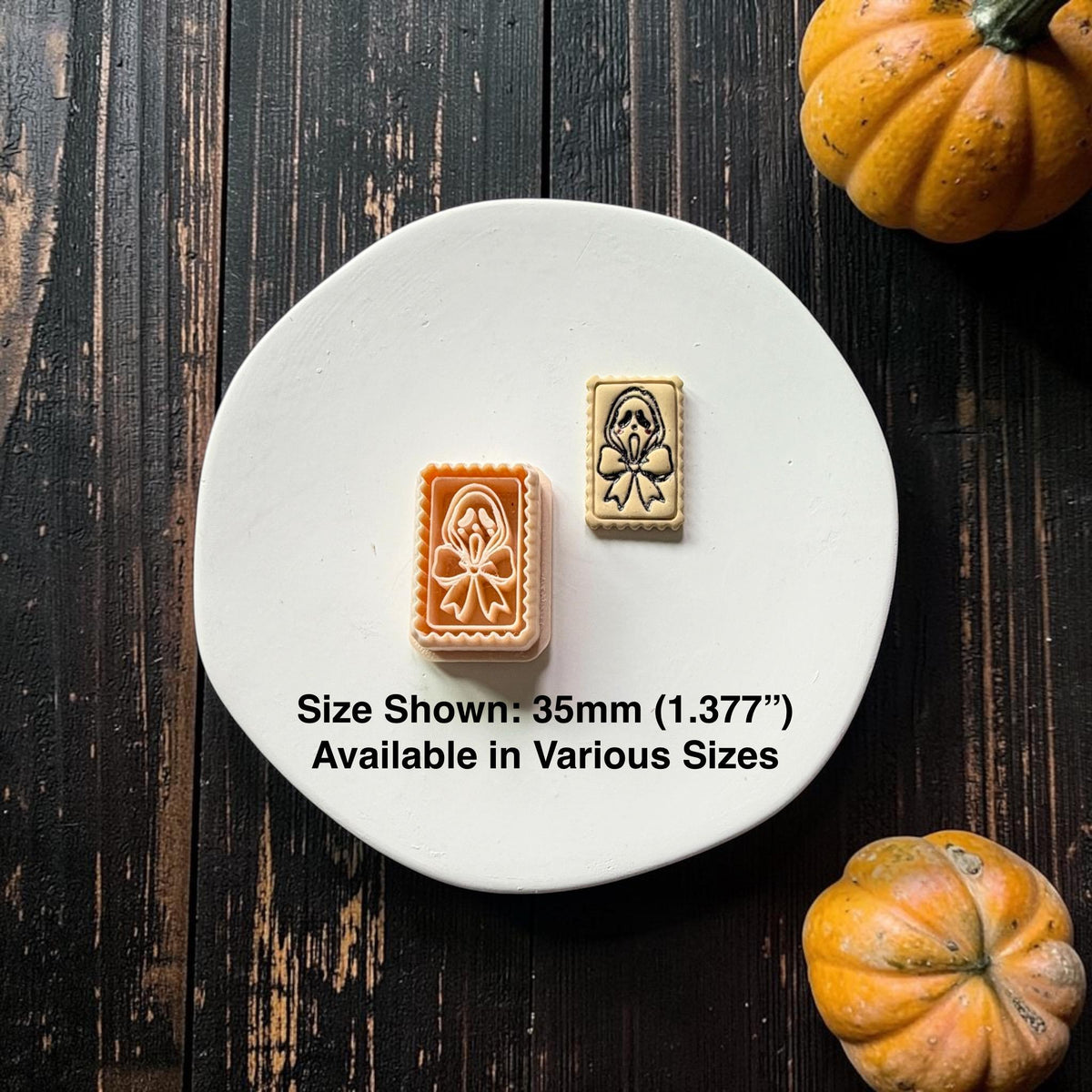 Peach ghost and bow clay cutter beside a finished cream-colored clay example with black details on a white plate; text states size shown is 35mm and various sizes are available.