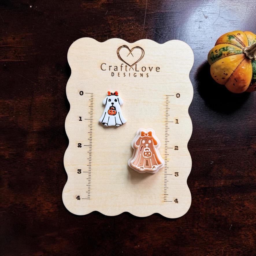 Finished ghost dog clay piece and matching peach design displayed on a Craft Love Designs wooden measuring board, showing their relative sizes beside the printed ruler markings.