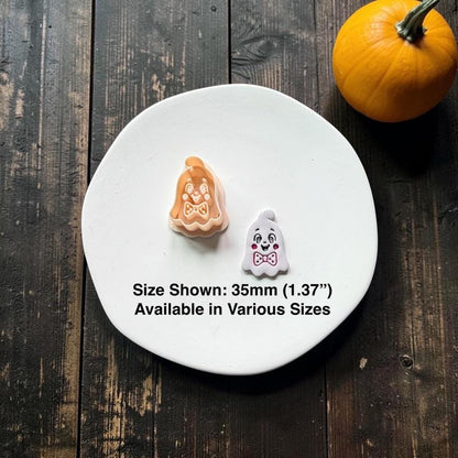 Vintage ghost polymer clay cutter beside a finished white ghost clay piece with black facial details, pink cheeks, and pink bow tie; text shows 35mm (1.37") and notes various sizes are available.