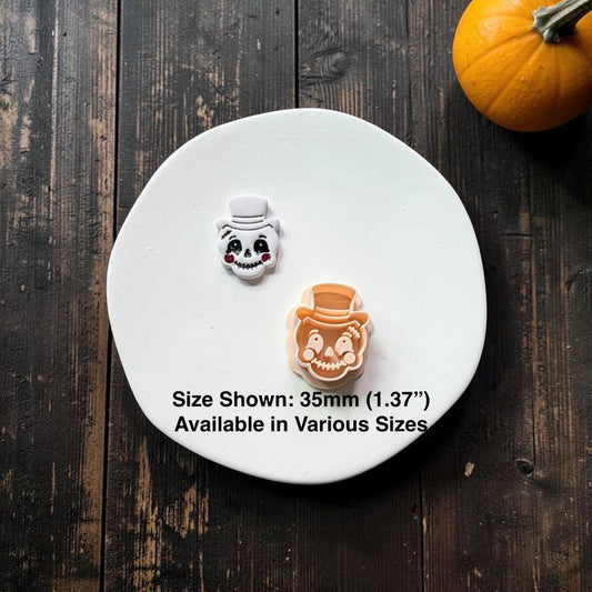 Finished vintage top hat pumpkin face beside the peach-colored polymer clay cutter, with text stating size shown is 35mm (1.37") and available in various sizes.