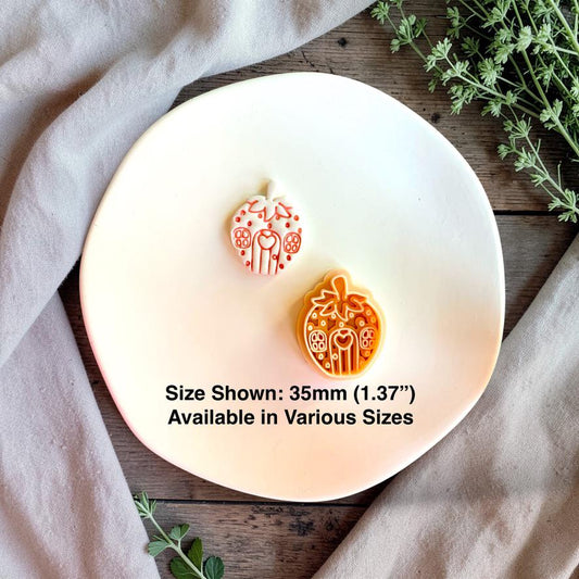 Finished white strawberry house clay piece displayed beside the orange design on a white plate, with text stating size shown is 35mm (1.37 inches) and various sizes are available.