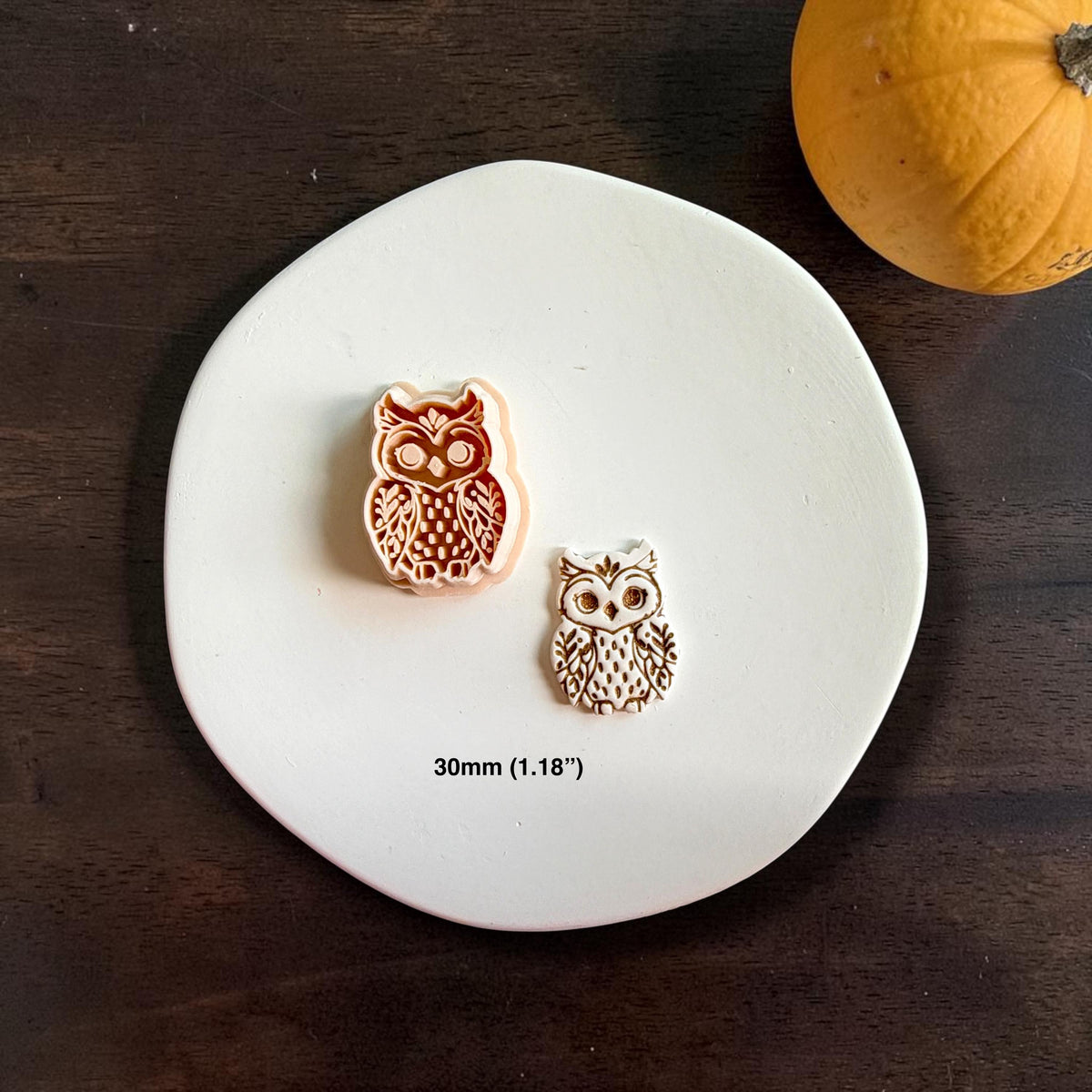 Ornate owl polymer clay cutter beside the finished white owl clay piece on a white plate, with a small orange pumpkin and a size label showing 30mm.
