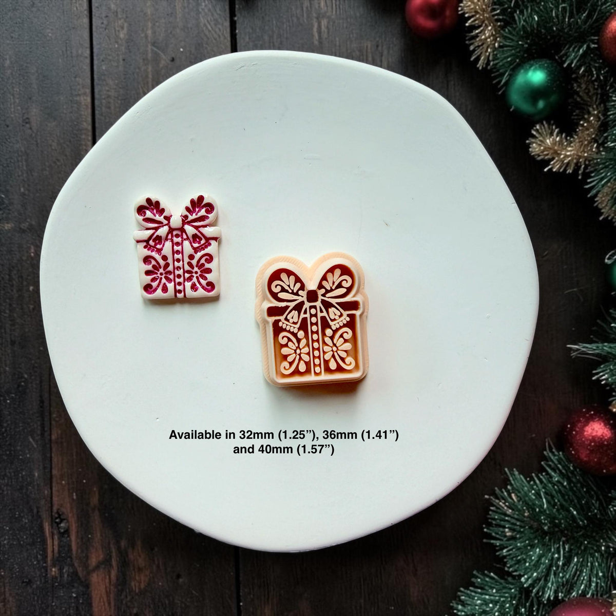 Small white and red Christmas present beside a larger red and cream version on a white surface. Both feature decorative bows, ribbons, dots, and floral folk art details. Available sizes shown are 32mm (1.25"), 36mm (1.41"), and 40mm (1.57").