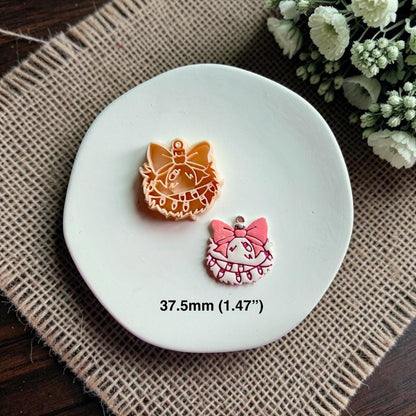 Tan clay cutter and finished pink and white ornament displayed together on a white plate over burlap, with flowers in the background and text showing the 37.5mm (1.47") size.