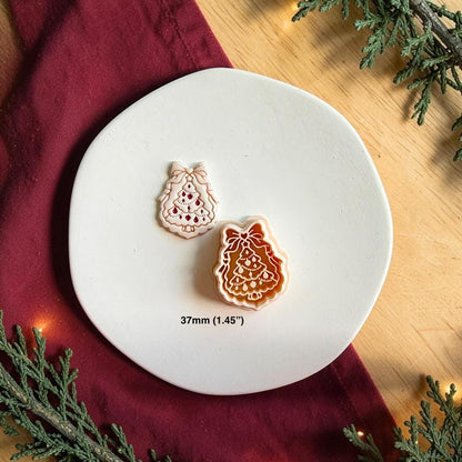 Finished bow Christmas tree clay piece beside the matching polymer clay cutter on a white plate, with text showing the 37mm or 1.45 inch size.