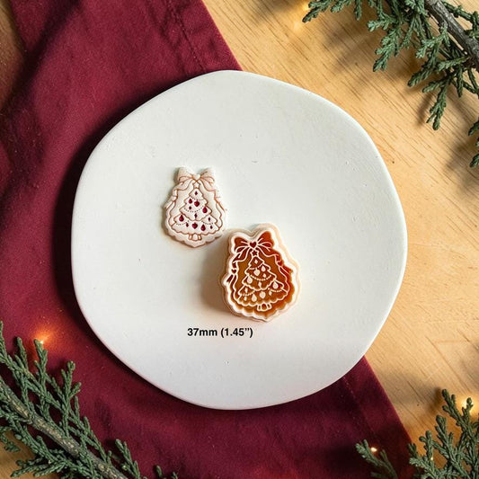 Finished bow Christmas tree clay piece beside the matching polymer clay cutter on a white plate, with text showing the 37mm or 1.45 inch size.
