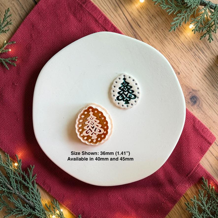 Christmas tree polymer clay cutter beside the finished white oval tree piece on a white plate, with text showing the 36mm size pictured and availability in 40mm and 45mm.