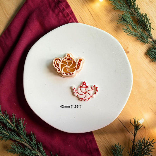 Peppermint teapot polymer clay cutter beside the finished red and white teapot clay piece on a white plate, with text showing the 42mm or 1.65 inch size.